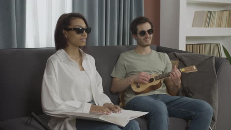 blind friends sitting on a sofa in a flat