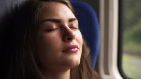 woman tourist traveling by train. local train. young female relaxing sleeping in modern train. slight natural shaking. close up