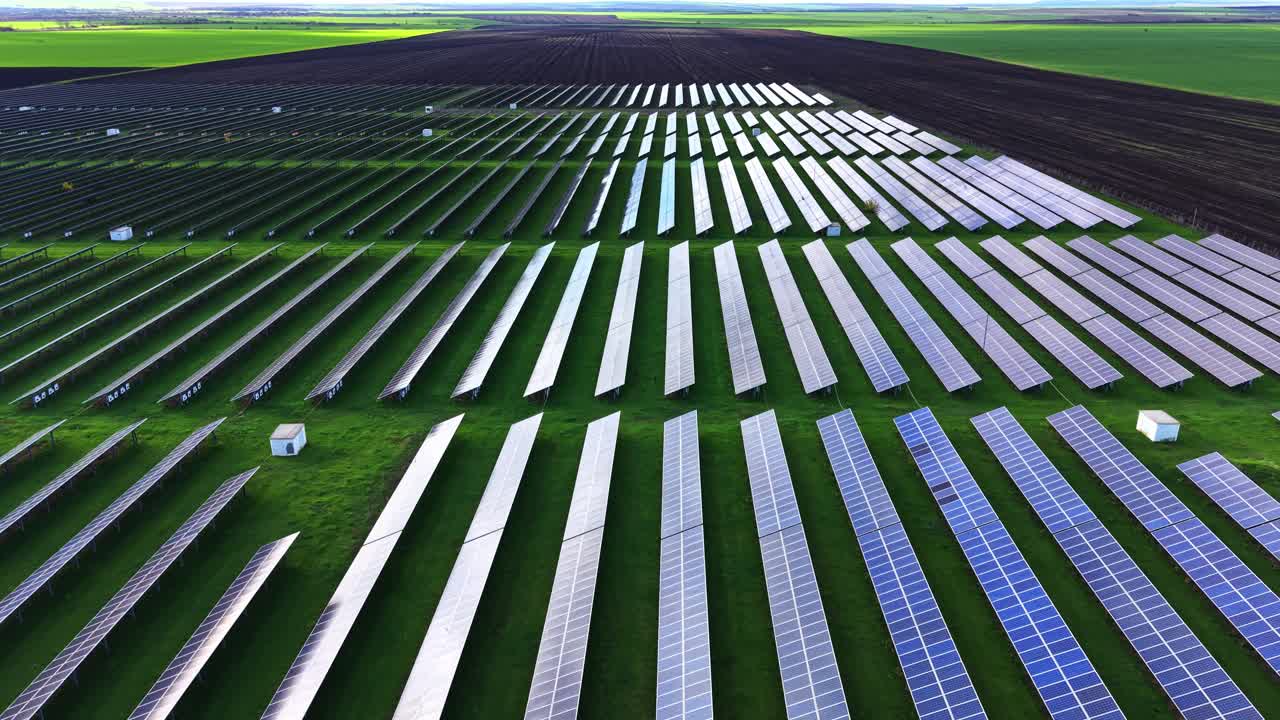 Expansive solar farm with rows of panels under clear blue sky