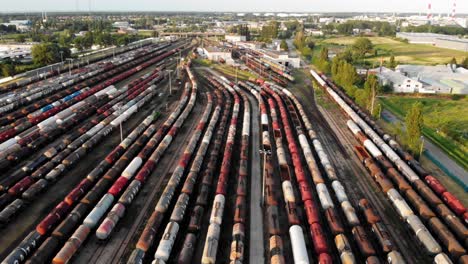 aerial dolly shot showing large train depot with many colorful cargo trains