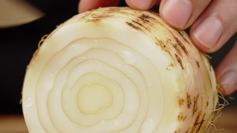 expertly preparing a fresh onion: the art of slicing for culinary perfection, showcasing the layers and textures of a vital kitchen ingredient