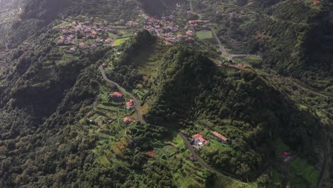 incline hacia arriba la toma de drones de pequeñas casas y campos en un pueblo de madeira