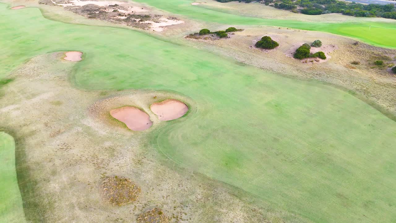Drone footage captures the expansive greens and coastal beauty of Barwon Heads, Victoria, under bright daylight