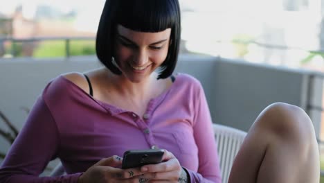 mujer usando teléfono móvil en el balcón 4k
