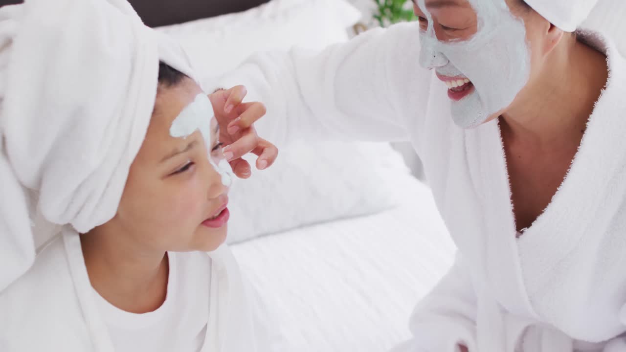 복장을 입은 행복한 아시아 어머니와 딸의 비디오는 얼굴에 수분을 공급하고 재미를 느끼고 있습니다.