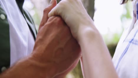 close-up of romantic couple holding hands in garden