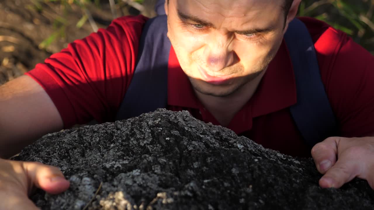 Man try hard for to climb on a steep cliff. Mountain climber on natural rocky wall. Young man takes a step towards success. Fearless and extreme. Climber makes hard move. Overcoming difficulty