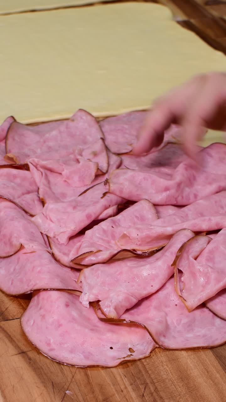 Placing ham slices on dough for Venezuelan ham bread