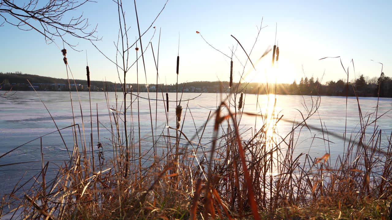 일몰에 의해 겨울에 얼어붙은 호수의 팬 샷