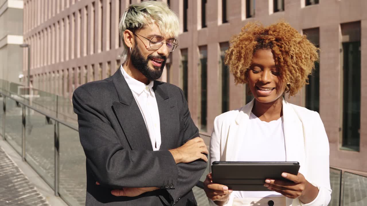 Des professionnels discutent de travail sur une tablette en extérieur