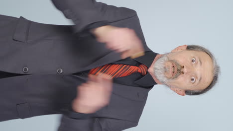 video vertical de un viejo hombre de negocios dando un discurso motivacional a la cámara.