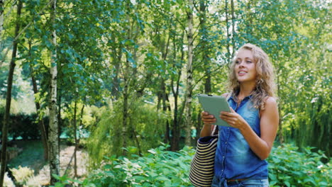 a young attractive woman walks in a well-groomed park on a summer day 2