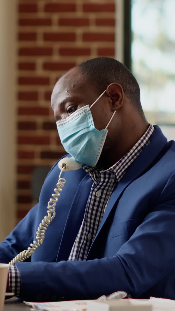 Man wearing face mask using phone in office