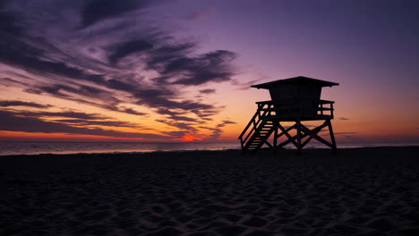 lifeguard stand silhouette at sunset on a vibrant beach