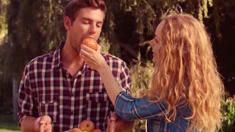 happy woman giving apple to her husband