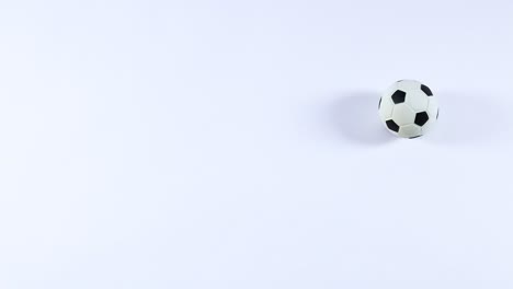 a football rolls smoothly across a white surface