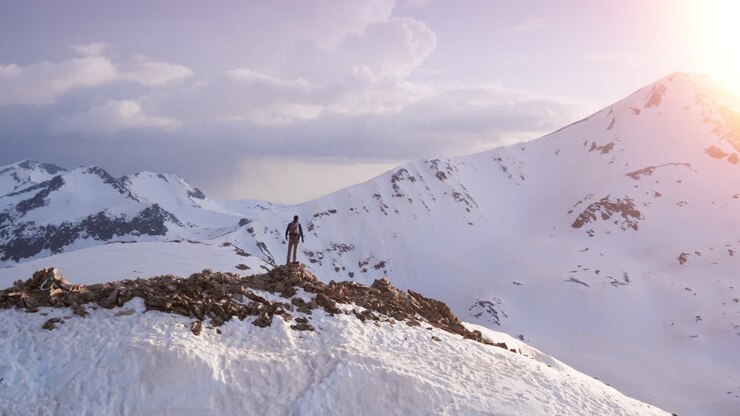 el excursionista llega a la cumbre de la montaña al amanecer
