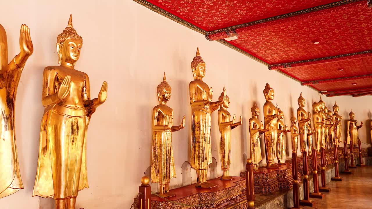 fila de estatuas de oro de buda en un templo