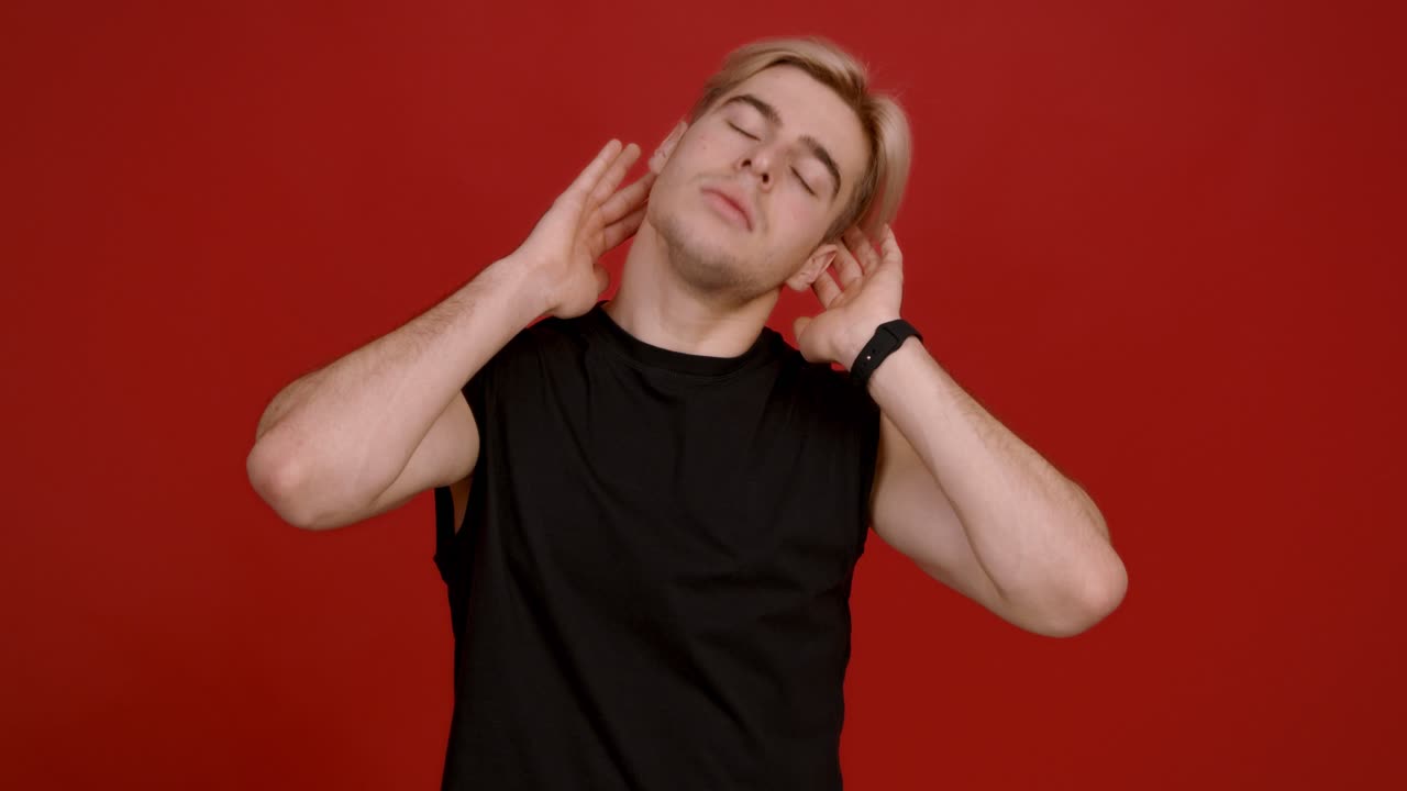 hombre estirando su cuello frente al fondo rojo