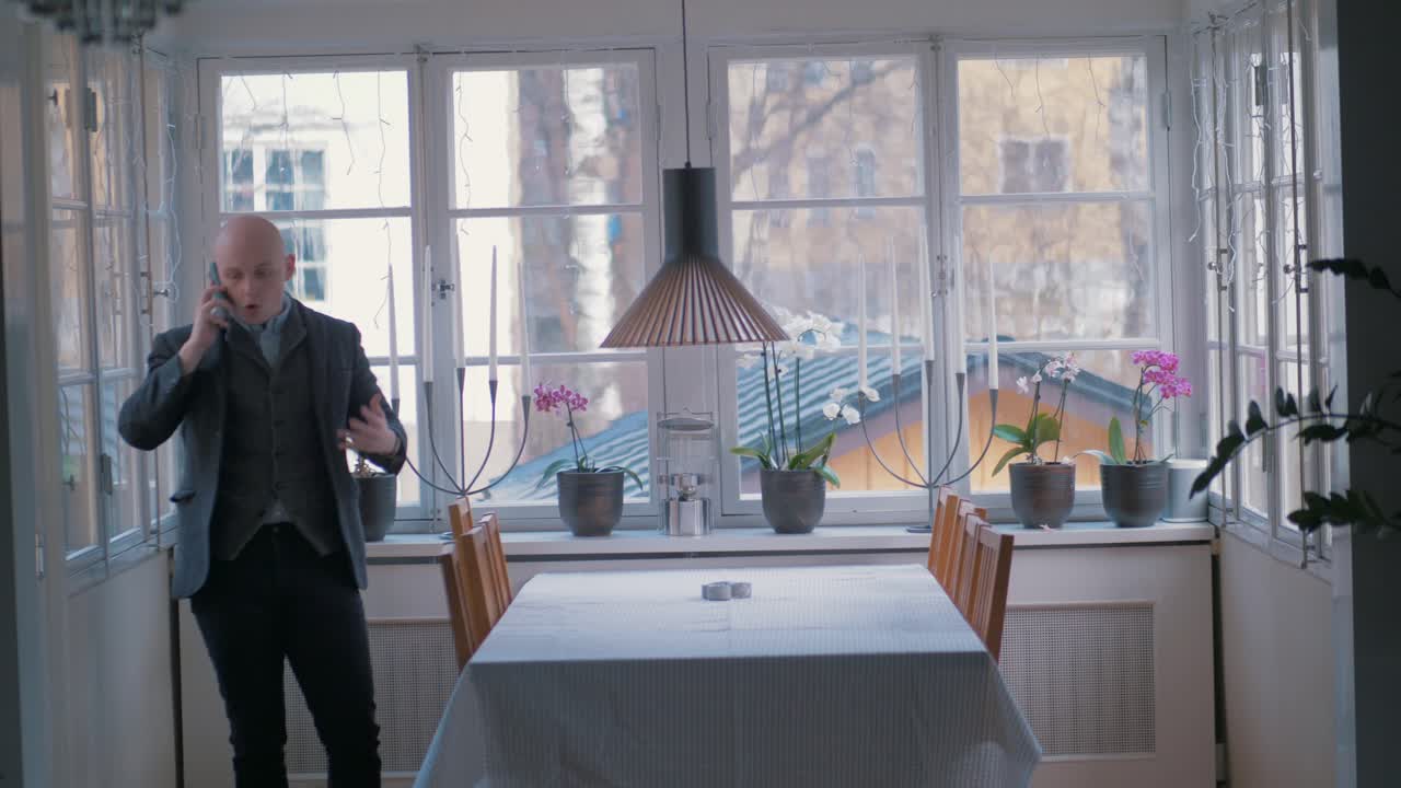 мужчина сердито разговаривает по телефону, работая на дому