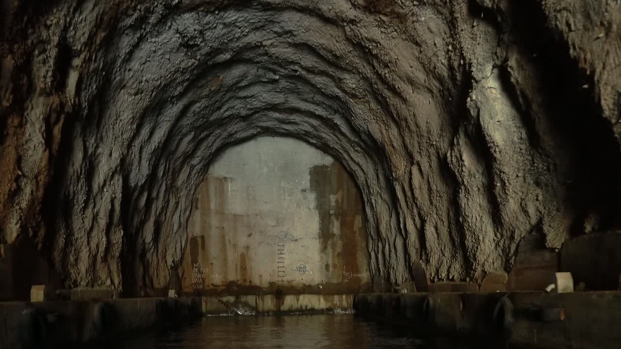 Moving deeper into an abandoned cold war submarine bunker in Montenegro Bay of Kotor