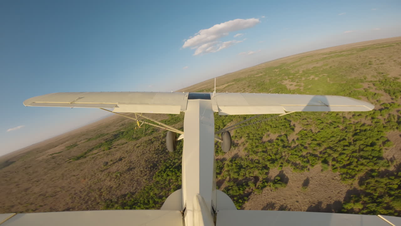 Avioneta volando sobre la sabana verde