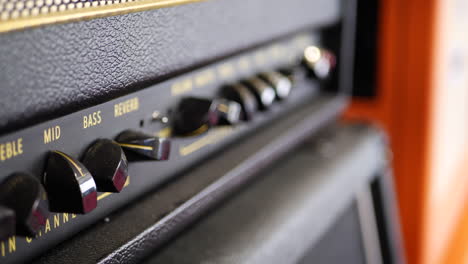 a vintage tube electric guitar amplifier with equalizer knobs in a music studio for recording rock and roll