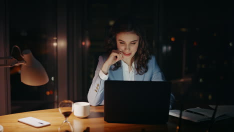 female workaholic sitting office looking laptop monitor with smile close up.