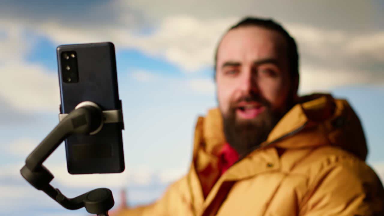 Vlogger che registra un video con smartphone su un treppiede che riprende una vista panoramica