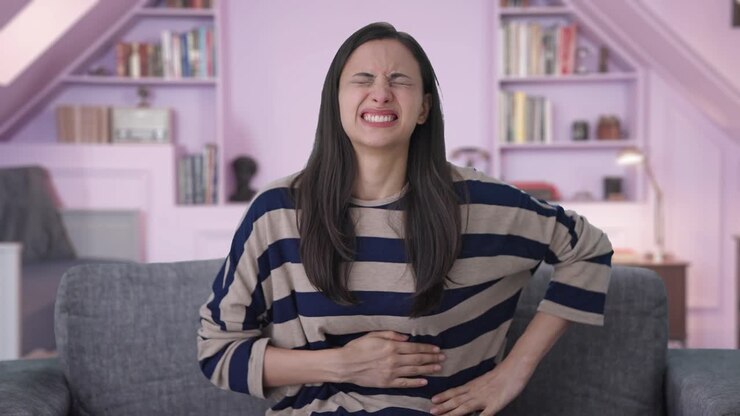 chica india enferma que sufre de dolor de estómago