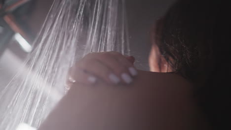 la mujer disfruta del calor de la ducha limpiando el cuerpo. la mujer disfraza de la agradable sensación de limpieza del cuerpo. la dama se baña encontrando consuelo en el agradable calor