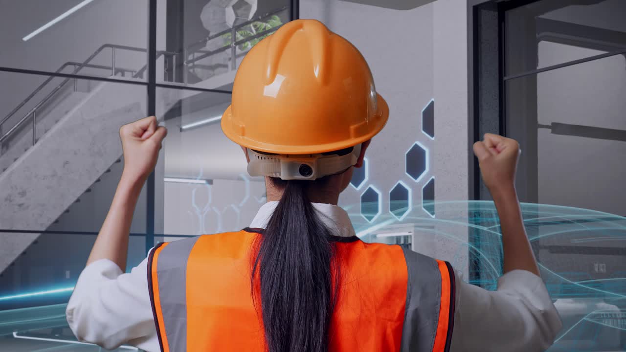 vista posterior cercana de una ingeniera con casco de seguridad levantando las manos celebrando mientras trabaja con el concepto de vehículo eléctrico
