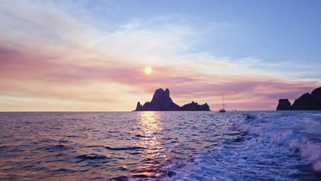 Sonnenuntergangsaufnahme-Von-Es-Vedra,-Das-Mit-Dem-Boot-Wegfährt