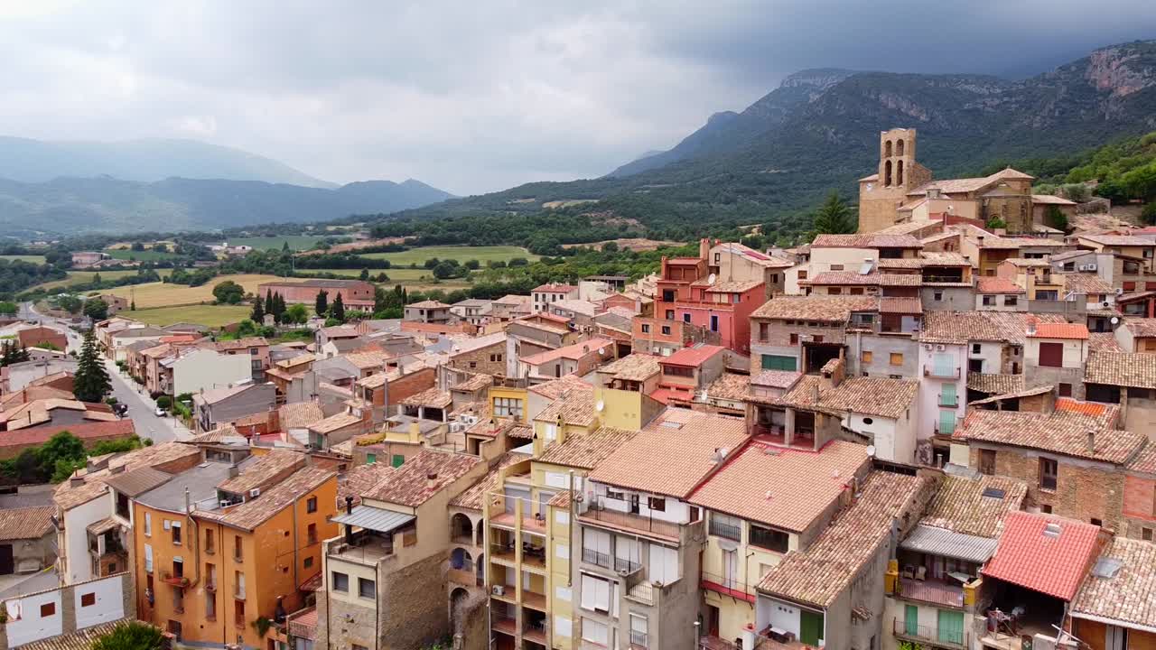 pueblo rural en lerida, cataluña, norte de españa - vista aérea de drones del colorido pueblo y las montañas nubladas
