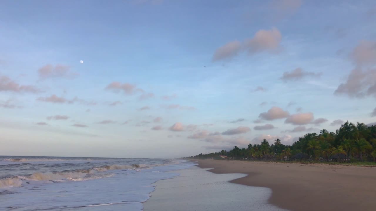 Waves on a Caribbean Sea beach with beautiful skies during sunset