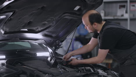 using digital tablet for a car diagnostic. mechanic using a tablet pc at the repair service. interactive diagnostics software on an advanced computer.