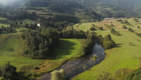 volar lentamente sobre el hermoso río del país y las colinas verdes en el fondo