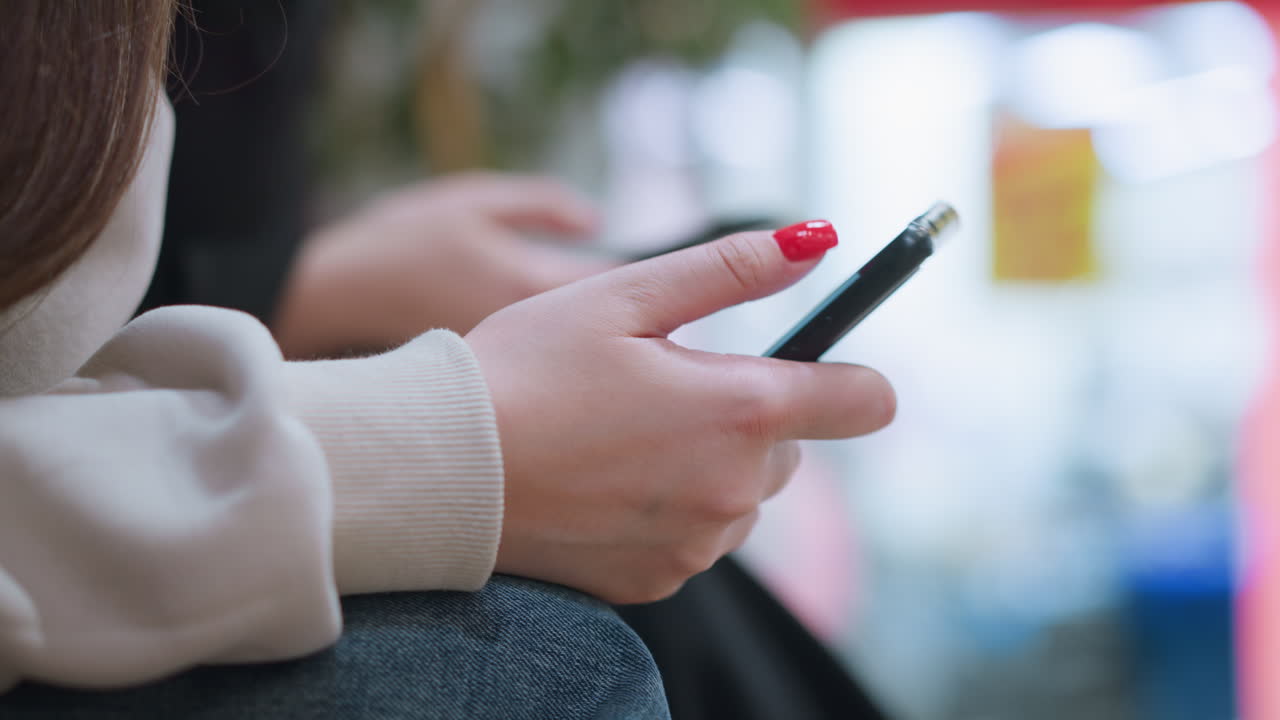 Close up of hands holding phones indoors focus on casual gadget use showing digital lifestyle technology and communication concept with blurred background