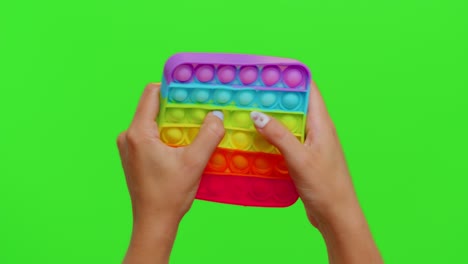 female hands with push pop it bubble fidget stress anxiety relief squeeze sensory toy on chroma key