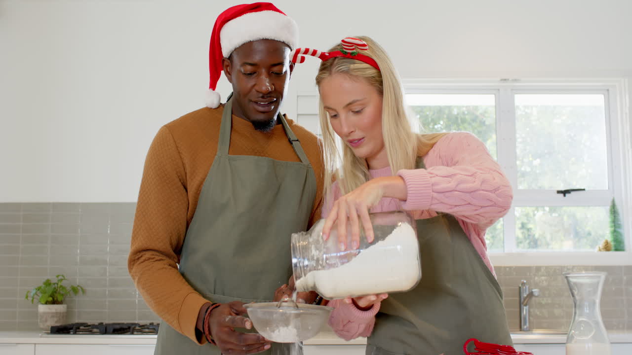 Baking together, diverse couple preparing for Christmas in kitchen, smiling happily