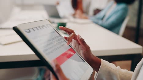 a businesswoman working on a tablet in an office setting.