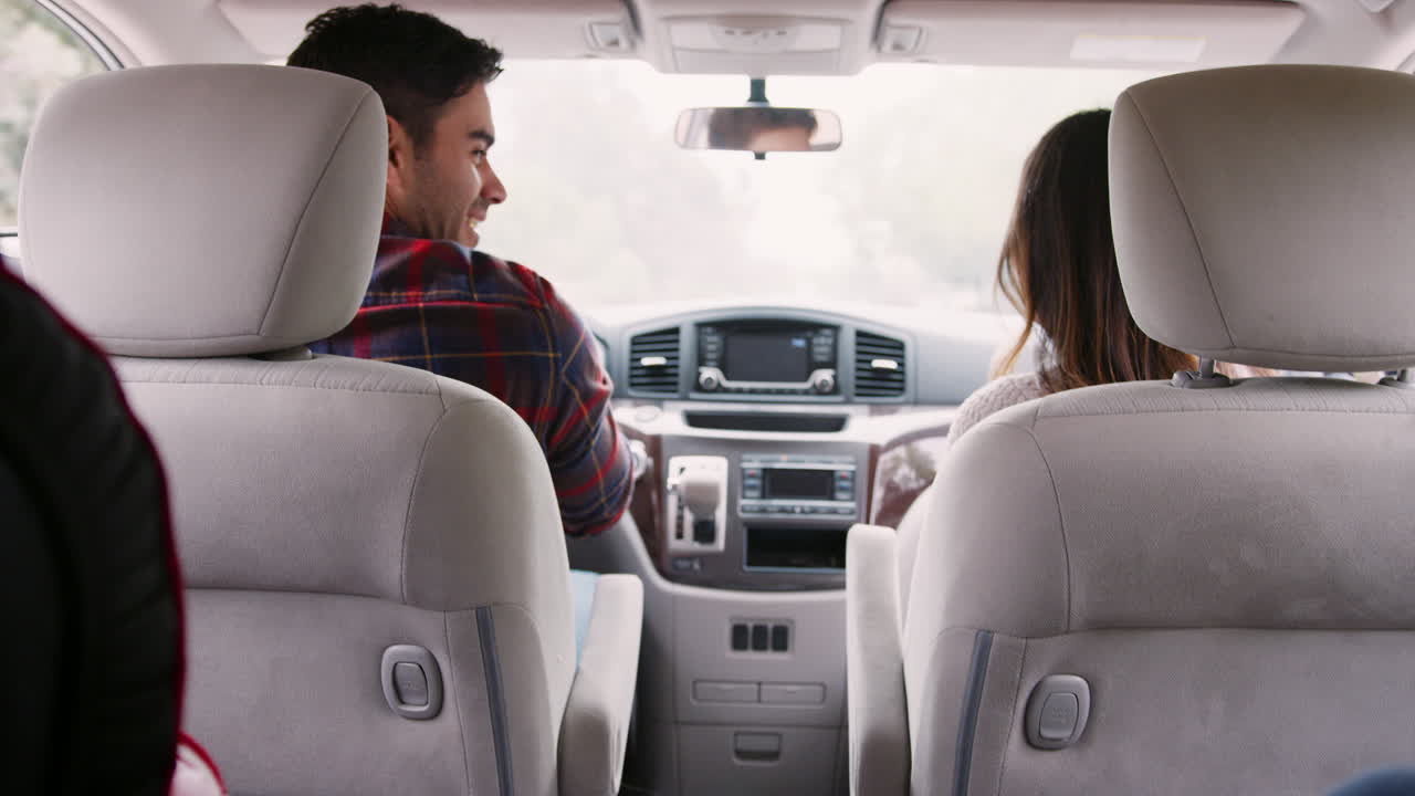 madre se da la vuelta a sus hijos en el asiento trasero del coche