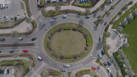 vista aérea de arriba hacia abajo de los coches que van alrededor de una rotonda de tráfico ocupado