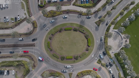 top down aerial view of cars going around a busy traffic roundabout