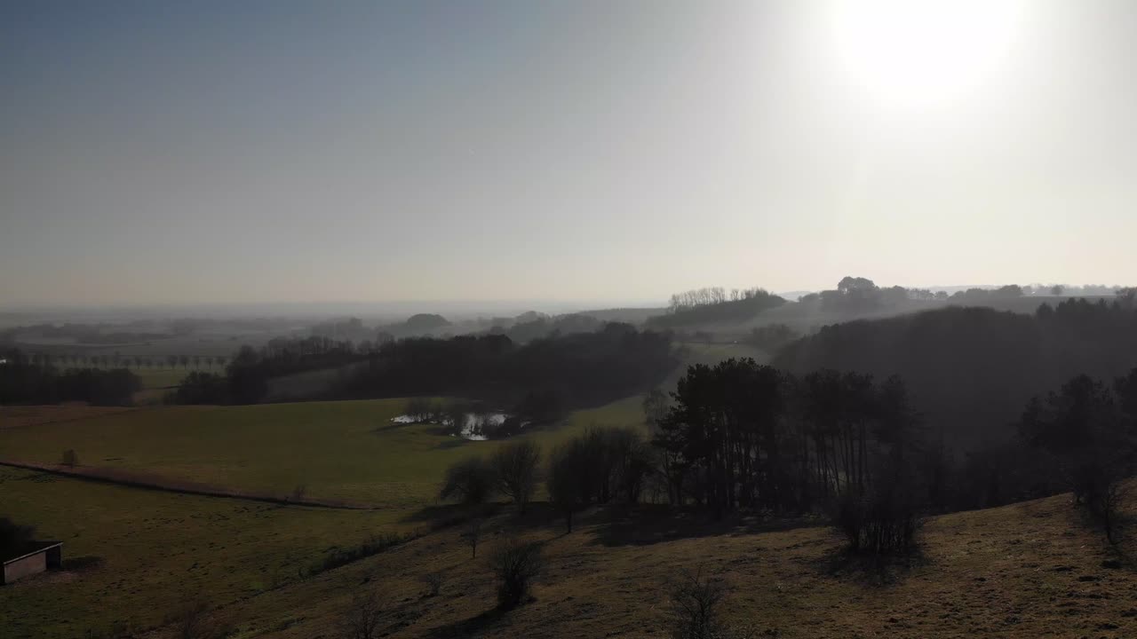 나무와 호수가 있는 아름다운 푸른 언덕의 공중 전망, 덴마크 odsherred의 일몰을 향해 이동