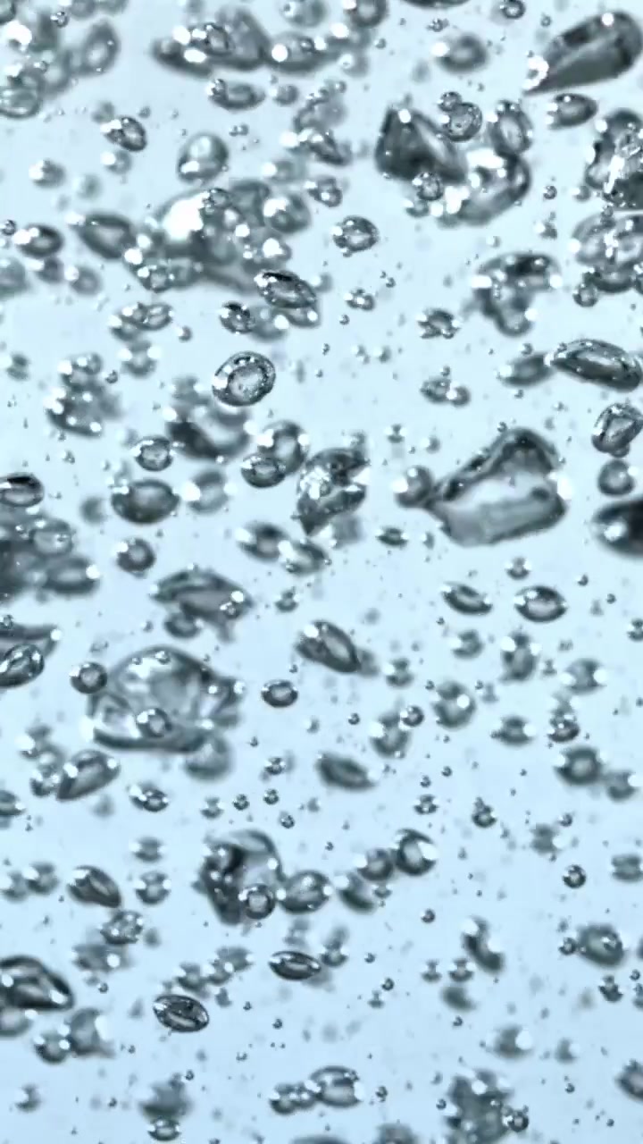 Primo piano di bollicine scintillanti che salgono in un liquido trasparente