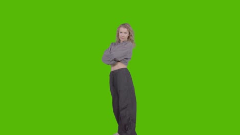 full length studio portrait of young woman with attitude against green screen