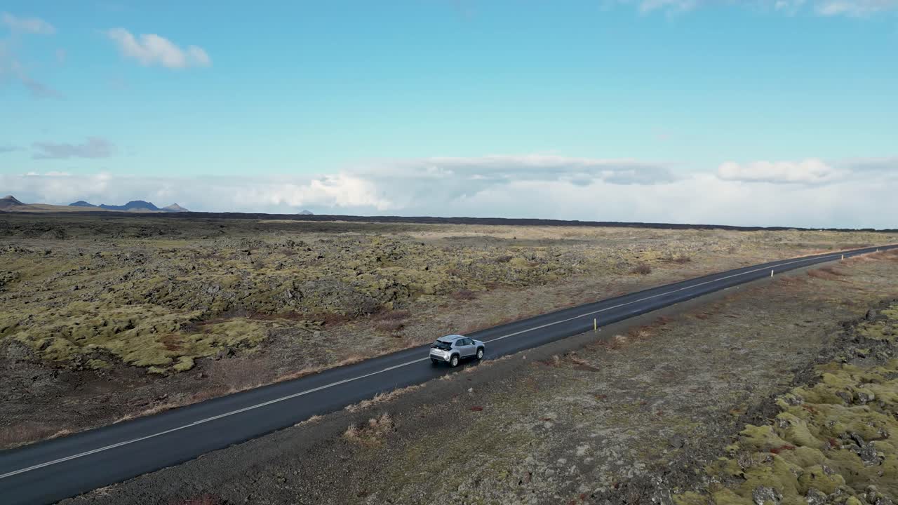아이슬란드에서 예정된 장소로 향하는 길에서 황폐한 풍경을 통해 이동하는 차량을 관찰하는 것