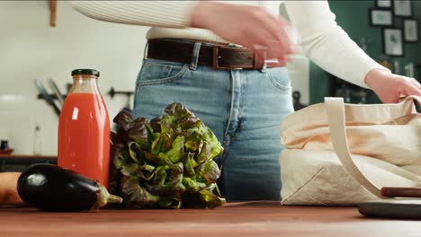 woman putting groceries into a reusable shopping bag