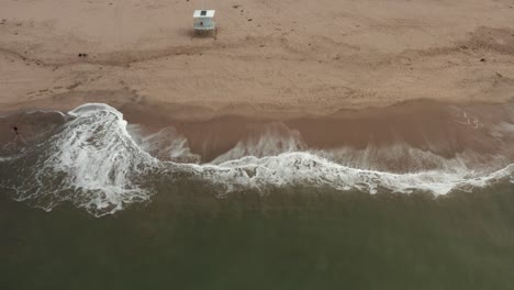 drone shot of shore of beach with life guard towers along the beach in santa cruz